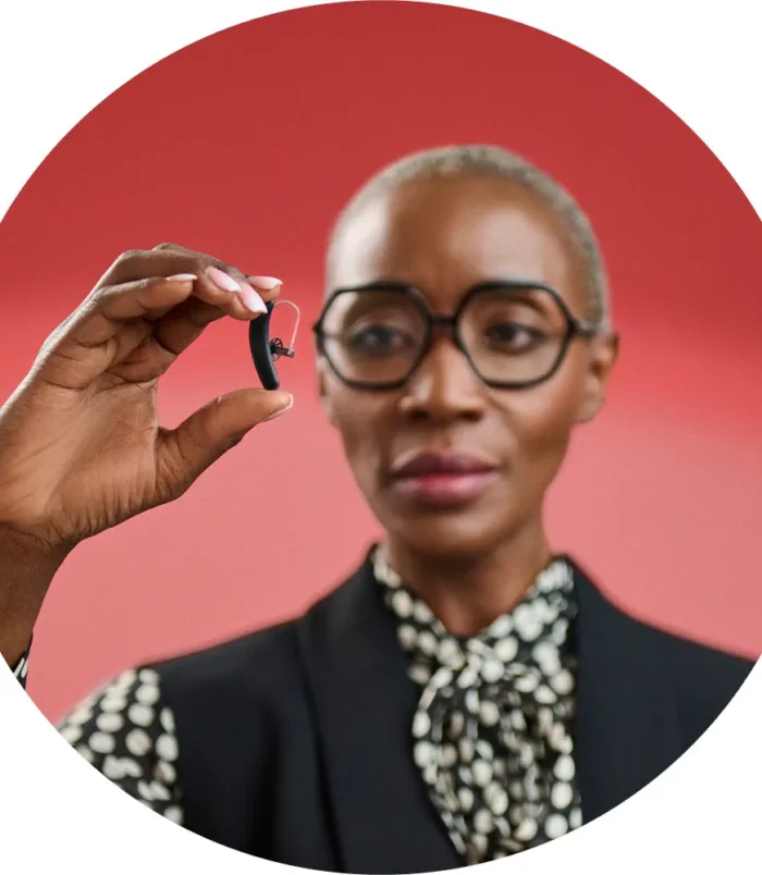 Styletto-IX_woman-holding-hearing-aid_circle_1000x1000